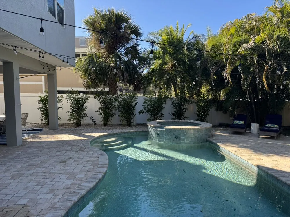 Landscaped pool and patio area with potted plants